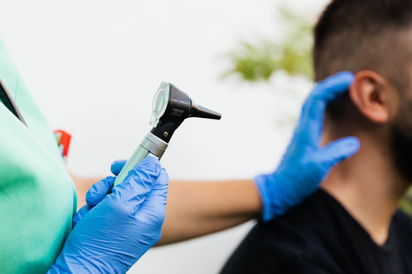 Clinician holding an otoscope ready to examine a patient's ear